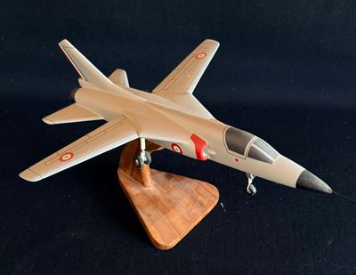 une maquette d'avion de chasse posée sur un socle en bois