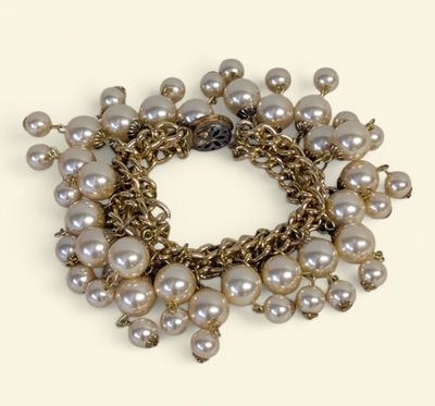 bracelet orné de perles et de chaînes en or sur fond blanc