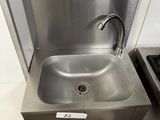 a stainless steel sink with a faucet in the corner