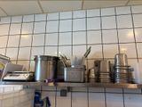 de nombreuses casseroles et poêles sur l'étagère de la cuisine
