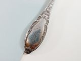 a silver spoon on a white surface with a blue background