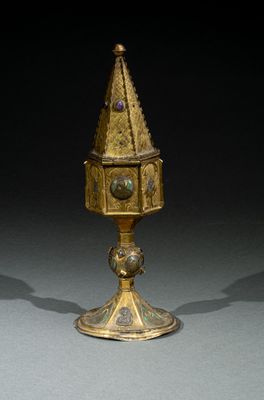 une coupe en or richement décorée, surmontée d'une horloge