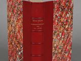 an open book with a red cover sitting on top of a table