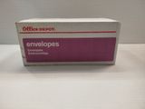 des enveloppes « Boxed Office Depot » rangées dans une boîte posée sur une surface blanche