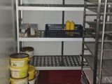 une pièce dans laquelle se trouvent une étagère, des étagères et des seaux