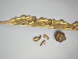 a gold leaf and flower decoration on a white surface