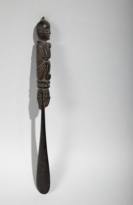 a spoon with a carving on it sitting on a table