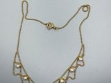 un collier en or avec des perles sur une chaîne