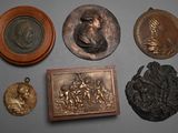 a lot of bronzes on a table with a picture of a man
