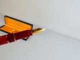 un stylo rouge posé sur une table blanche
