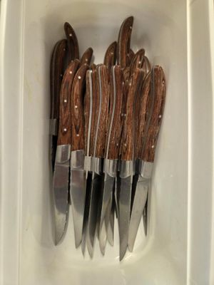 cinq couteaux dans un récipient blanc muni d'un manche marron