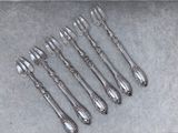 six fourchettes et cuillères en argent plaqué, posées sur un fond gris