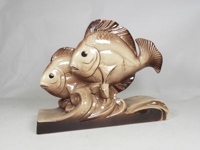 a figurine of a fish and a fish on a wave