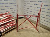 a pile of red and white skis sitting on a pallet in front of a wall