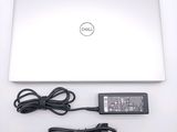 a dell laptop and a charger on a white table
