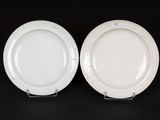 two white plates on a black table with a black background