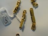 some gold chains and a tag on a white surface