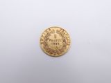 a gold coin on a white surface with a white background