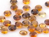 some yellow and brown gems are scattered on a white surface