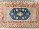 un tapis bleu et orange orné d'un motif en losanges