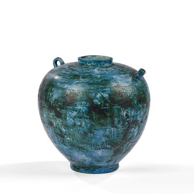 un vase bleu posé sur une surface blanche