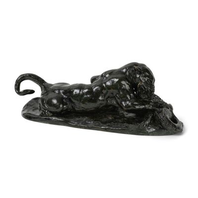 sculpture noire représentant un bélier couché sur une feuille posée sur une surface blanche