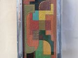 painting of abstract shapes in a silver frame hanging on a wall