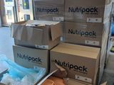 Plusieurs cartons de « Nutpack » sont empilés les uns sur les autres dans un entrepôt.