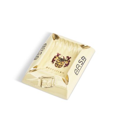 une image représentant un cendrier blanc et doré orné d'un blason