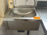 un lavabo dans un coin d'une salle de bains dotée d'une fenêtre