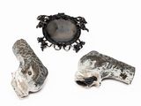 three pieces of silver and black jewelry on a white surface