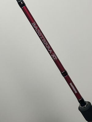 a close up of a person holding a fishing rod with a red handle