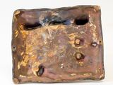 a small bronze plate with a bird on it
