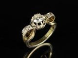 gros plan d'une bague en or et diamants sur une surface noire