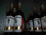 several bottles of liquor are lined up on a shelf in a store