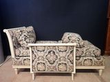 an upholstered chaise lounger in a room with a blue wall