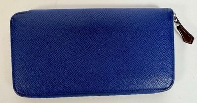 a close up of a blue purse on a white surface