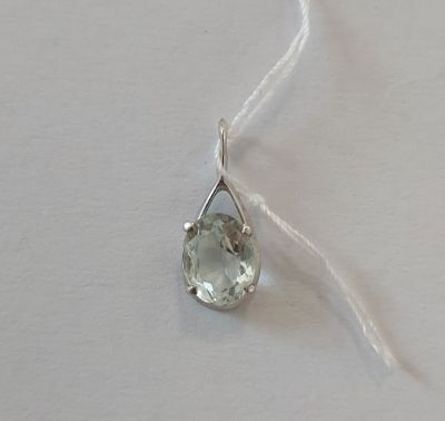 un gros plan d'un collier en argent orné d'une pierre verte montée sur un fil