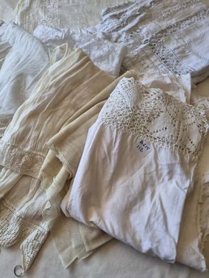 un tas de vêtements sur un lit recouvert d'une couette blanche