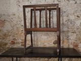a wooden chair sitting on top of a wooden table