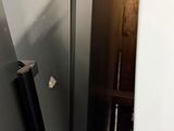 a silver refrigerator in the corner of a room