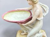 a figurine of a woman holding a bowl