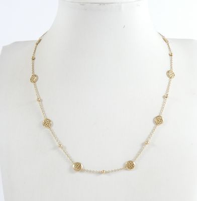 a gold and white beaded necklace on a mannequin mannequin mannequin mannequin mannequin mannequin mannequin manne