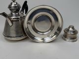 a silver tea pot and a silver teapot on a table