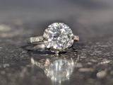 a diamond ring sitting on top of a shiny surface
