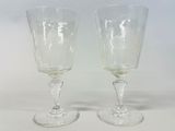 two empty wine glasses sitting next to each other on a table