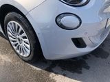 a small white car parked on the side of the road
