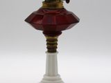 une lampe à l'ancienne surmontée d'un abat-jour en verre rouge