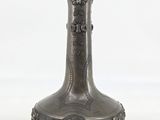 a silver vase sitting on a white surface with a white background
