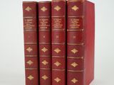 trois livres rouges sont empilés sur une surface blanche